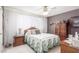 Cozy main bedroom featuring wood furniture, hardwood floors, a ceiling fan and bright natural light at 13019 N 98Th Ave, Sun City, AZ 85351