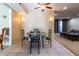 Charming dining area featuring tile floors, table with a colorful cover, and a view into the living room at 13404 W Copperstone Dr, Sun City West, AZ 85375