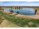 Scenic view of a lush green golf course with a tranquil lake and blue sky at 13404 W Copperstone Dr, Sun City West, AZ 85375