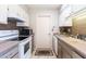 Efficient kitchen showcasing white cabinets, neutral countertops, and ample storage space at 13404 W Copperstone Dr, Sun City West, AZ 85375