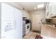 Bright kitchen featuring white appliances, tile flooring, ample cabinetry, and a skylight at 13404 W Copperstone Dr, Sun City West, AZ 85375