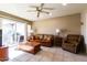 Cozy living room with tiled flooring, a ceiling fan and patio door at 13404 W Copperstone Dr, Sun City West, AZ 85375