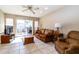 Cozy living room with tiled flooring, a ceiling fan and patio door at 13404 W Copperstone Dr, Sun City West, AZ 85375