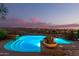 A refreshing pool illuminated at dusk, surrounded by desert landscape at 15501 E Tepee Dr, Fountain Hills, AZ 85268