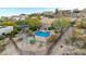 Backyard view showcasing a sparkling blue pool, desert landscaping, and wrought iron fence at 15501 E Tepee Dr, Fountain Hills, AZ 85268