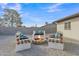 Outdoor entertaining space with a custom seating around a fire pit and gravel landscaping at 16239 N 47Th Dr, Glendale, AZ 85306