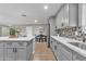 Modern kitchen with stainless steel appliances, grey cabinets, quartz counters, and decorative backsplash at 16239 N 47Th Dr, Glendale, AZ 85306