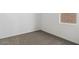 A bright bedroom featuring neutral carpet, white walls, and a window offering natural light at 1689 N Fenway Dr, Florence, AZ 85132