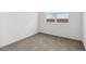 A bright bedroom featuring neutral carpet, white walls, and a window offering natural light at 1689 N Fenway Dr, Florence, AZ 85132