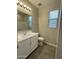 Full bathroom features a single vanity, framed mirror, wood-look tile floor, and a shower/tub combo at 17916 W Puget Ave, Waddell, AZ 85355