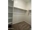 Walk-in closet with built-in shelving and hanging rods, offering ample storage space at 17916 W Puget Ave, Waddell, AZ 85355