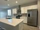 Modern kitchen with white cabinets, stainless steel appliances, and large island with sink at 17916 W Puget Ave, Waddell, AZ 85355