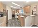 A bright kitchen showcasing a peninsula, appliances, and wood-look floors at 1936 S Mariposa Rd, Apache Junction, AZ 85119