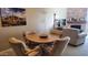 Dining area with a round wood table, upholstered chairs, and a decorative stone fireplace in the background at 205 N 74Th St # 234, Mesa, AZ 85207