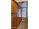 Hallway featuring light wood cabinets, a window with blinds, and wood-look floors at 205 N 74Th St # 234, Mesa, AZ 85207