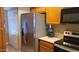 Modern kitchen with stainless steel refrigerator, dark appliances, and ample cabinet space for storage at 205 N 74Th St # 234, Mesa, AZ 85207