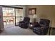 Comfortable living room with leather chairs and access to a balcony provides a relaxing space with natural light at 205 N 74Th St # 234, Mesa, AZ 85207