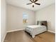 Bedroom with hardwood floors, a ceiling fan, and a large window overlooking the street at 2081 E Aquarius Pl, Chandler, AZ 85249