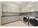 Well-equipped laundry room with ample counter space, storage cabinets, and modern appliances at 2081 E Aquarius Pl, Chandler, AZ 85249