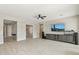 Open living room features tile floors, a ceiling fan, and a media center with a large screen television at 2081 E Aquarius Pl, Chandler, AZ 85249