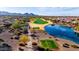 Aerial view of community golf course, lake, desert landscaping, and homes in the distance at 21500 N 262Nd Ln, Buckeye, AZ 85396