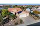 Aerial view of a desert home featuring a three car garage, solar panels, tile roof, and manicured landscaping at 21500 N 262Nd Ln, Buckeye, AZ 85396