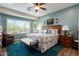 Serene main bedroom featuring a king-sized bed, plush rug, and sunlit windows with desert views at 21500 N 262Nd Ln, Buckeye, AZ 85396