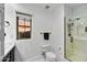 Bright bathroom features a glass-enclosed shower, white marble floors, and views from the window at 22317 N 39Th Run, Phoenix, AZ 85050