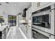 Modern kitchen with stainless steel appliances, stone backsplash, and marble floor at 22317 N 39Th Run, Phoenix, AZ 85050