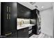 Modern laundry room with sleek black cabinets, gold hardware, and stacked washer/dryer at 22317 N 39Th Run, Phoenix, AZ 85050