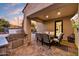 Outdoor kitchen on a brick patio with a built-in grill, seating, and a view of the pool at 22317 N 39Th Run, Phoenix, AZ 85050