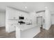 Modern kitchen featuring white cabinetry, stainless steel appliances, and a spacious quartz countertop island at 22679 E Estrella Rd, Queen Creek, AZ 85142