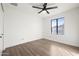 A bright and empty bedroom features hard wood floors, modern ceiling fan, and a large window at 2305 S Orange --, Mesa, AZ 85210