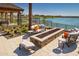 Outdoor patio area featuring comfortable seating and a modern firepit, with a view of the lake and surrounding landscape at 25109 N 174Th Ln, Surprise, AZ 85387