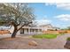 An inviting backyard with a lush green lawn, mature trees, and decorative gravel is ideal for outdoor relaxation at 2520 W Minton St, Phoenix, AZ 85041