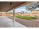 A covered patio features a landscaped backyard with green grass, gravel, and ambient string lights at 2520 W Minton St, Phoenix, AZ 85041