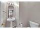 Powder room features a pedestal sink, toilet, and mirror at 2738 W Silver Fox Way, Phoenix, AZ 85045