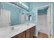 Bathroom featuring double sinks, a large mirror, wood cabinets, and light blue walls at 2738 W Silver Fox Way, Phoenix, AZ 85045