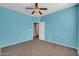 Bedroom with light blue walls, neutral carpet, and lighted ceiling fan at 2738 W Silver Fox Way, Phoenix, AZ 85045