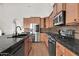 Modern kitchen features black counters, stainless appliances, tile backsplash, and light-colored cabinets at 2738 W Silver Fox Way, Phoenix, AZ 85045