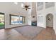 Bright living room with large windows overlooking the pool, a fireplace, and custom built-ins at 2738 W Silver Fox Way, Phoenix, AZ 85045