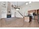 Open concept living room with adjacent kitchen, fireplace, staircase, and an abundance of natural light at 2738 W Silver Fox Way, Phoenix, AZ 85045