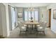 Modern dining room features a wooden table, chandelier, large window, and neutral walls at 3145 W Sandra Ter, Phoenix, AZ 85053