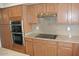 Kitchen space with built-in oven and cooktop, complemented by ample cabinet storage and granite countertops at 3145 W Sandra Ter, Phoenix, AZ 85053