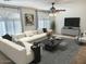 Inviting living room featuring stylish furniture, a TV, a modern ceiling fan, and bright windows with decorative curtains at 3145 W Sandra Ter, Phoenix, AZ 85053