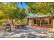 Inviting backyard patio with a grill, dining table, and lush, mature landscaping at 3237 E Meadowbrook Ave, Phoenix, AZ 85018