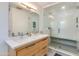 Bright bathroom featuring double sink vanity with quartz counters and a glass enclosed shower with built in bench at 3237 E Meadowbrook Ave, Phoenix, AZ 85018