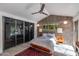 Serene bedroom featuring natural light, concrete accent wall, ceiling fan, and sliding mirrored closet doors at 3237 E Meadowbrook Ave, Phoenix, AZ 85018