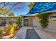 Inviting mid-century home with an elegant walkway, cacti, mature plants, and unique red accents on the front door at 3237 E Meadowbrook Ave, Phoenix, AZ 85018