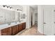 Bathroom featuring double sinks, tile floors, framed mirror, and a view into the toilet room at 3548 E Mesquite St, Gilbert, AZ 85296